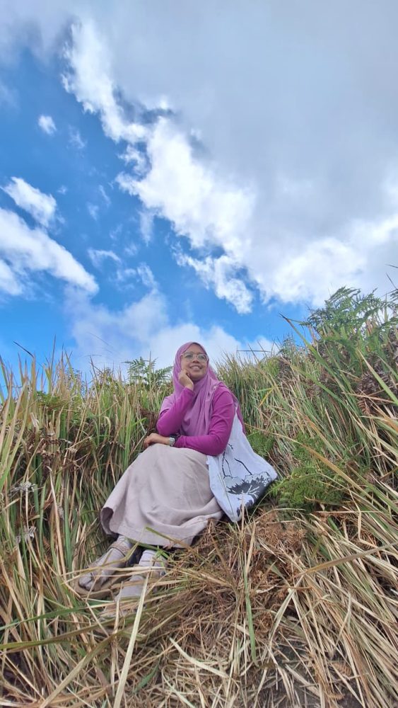 Momen Refleksi: Tentang Perjalanan, Bukan Sekadar Tujuan Di sabana, aku jadi mikir. Hidup kadang mirip perjalanan ke Bukit Premium ini. Kita bisa memilih jalan cepat, praktis, tapi mungkin ada cerita yang terlewat. Atau kita pilih jalan yang lebih susah, lebih lama, tapi di sepanjang jalan kita belajar banyak hal. Aku belajar sabar, belajar menikmati setiap langkah, bahkan belajar tertawa di tengah lelah. Dan yang terpenting, aku merasa lebih “nyambung” dengan alam. Bukit, angin, dan sabana seakan mengajarkan untuk pelan-pelan, menikmati, dan mensyukuri setiap hal kecil. Pulang: Jalan Ditutup, Cerita Bertambah Setelah puas menikmati sabana, aku akhirnya harus turun. Total perjalanan sekitar 12.000 langkah. Alhamdulillah melebihi target harian. Perjalanan pulang tentu lebih mudah karena jalannya menurun, tapi tetap saja lutut dan kaki lumayan protes. Namun kali ini aku sudah nggak peduli. Hati terlalu bahagia, dan pikiranku masih penuh dengan pemandangan cantik tadi. Sesampainya di bawah, aku menengok sebentar ke arah atas. Aku senyum sendiri. “Aku berhasil jalan kaki sampai atas,” batinku bangga. Bukan sekadar sampai, tapi juga membawa pulang banyak cerita Entah mengapa, perjalanan pulang rasanya lebih cepat dan lebih ringan. Alhamdulillah kami berhasil PP jalan kaki alias tanpa naik ojek. Sampai ke parkiran, kami pulang melewati Nongkojajar lagi. Namun, ternyata kami harus berhadapan dengan kejutan: banyak jalan ditutup. Rupanya ada acara lokal, mungkin berkaitan dengan truk-truk sound horeg yang kulihat tadi pagi. Resiko kalau travelling di Bulan Agustus. Wkkwkw.. Kami terpaksa muter lewat jalur lain, lebih panjang, lebih berliku. Awalnya kesal, tapi lama-lama aku tertawa sendiri. “Ya sudah, toh semakin lama di jalan, semakin panjang ceritanya,” batinku. Kadang perjalanan memang suka bercanda dengan kita, memberi kejutan di luar rencana. Jadiii.. yang awalnya kami mau lewat Nongkojajar, jadinya lewat Pakis dan Sawojajar. Langsung masuk tol menuju Surabaya. Bener-bener di luar skenario. Alhamdulillah perjalanan melewati Pakis aman tidak ada jalan ditutup. Keunikan alam Bukit Premium: Hamparan sabana luas yang hijau segar, mirip seperti Bukit Wairinding di Sumba Lanskapnya menghadirkan perbukitan berundak yang dramatis, dengan kabut tipis di pagi hari dan pemandangan Gunung Bromo, Semeru, hingga Arjuno dari kejauhan Cocok banget untuk foto-foto estetik, berburu sunrise atau sunset, piknik ringan, atau bahkan camping ground sederhana Tiket masuk dan parkir murah meriah buat scenery “premium”. Trekking ramah untuk pemula dan anak-anak, cukup landai dan pemandangannya “film alam” beneran Banyak spot instagramable Tips Kecil dari Perjalanan Premium Buat teman-teman yang ingin merasakan perjalanan ke Bukit Premium ala jalan kaki, ada beberapa hal kecil yang bisa jadi bekal: Bawa air minum cukup Percayalah, air mineral bisa jadi lebih nikmat daripada minuman manis apapun setelah tanjakan panjang. Pakai masker Selama perjalanan ada bagian yang penuh debu. Kenakan sepatu atau sandal gunung Jalan tanah dan bebatuan licin kalau habis hujan. Siapkan jaket tipis Udara di atas dingin, terutama pagi atau sore. Bawa snack ringan. Energi ekstra akan sangat berguna. Datang pagi atau sore. Sunrise dan sunset di sini katanya luar biasa. Tanya warga soal kondisi jalan. Siapa tahu ada penutupan jalur, jadi bisa siap dengan alternatif. Perjalanan kali ini mengajarkanku banyak hal. Bahwa premium itu bukan soal uang, tapi soal pengalaman. Premium adalah ketika kita tertawa di tengah capek, ketika kita menemukan keindahan di balik peluh, ketika kita menerima kejutan jalan yang ditutup tanpa mengeluh. Bukit Keciri, sang Sabana Guntur Loreng, mungkin hanya sebuah bukit di Pasuruan. Tapi bagiku, ia adalah guru kecil yang mengingatkan: nikmatilah proses, jangan buru-buru. Karena kadang, justru langkah-langkah paling beratlah yang membuat kita merasa paling hidup. Dan saat aku menoleh sekali lagi ke atas bukit sebelum pulang, aku tersenyum. Perjalanan ini bukan hanya tentang sampai, tapi tentang bagaimana aku melewati semua, dengan kaki yang pegal, hati yang penuh, dan cerita yang kini abadi dalam ingatan.